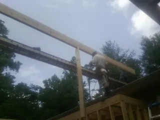 Carpenter setting a ridge beam over a new addition frame — Ice Dam Removal by Roofing Brothers in Conway Springs