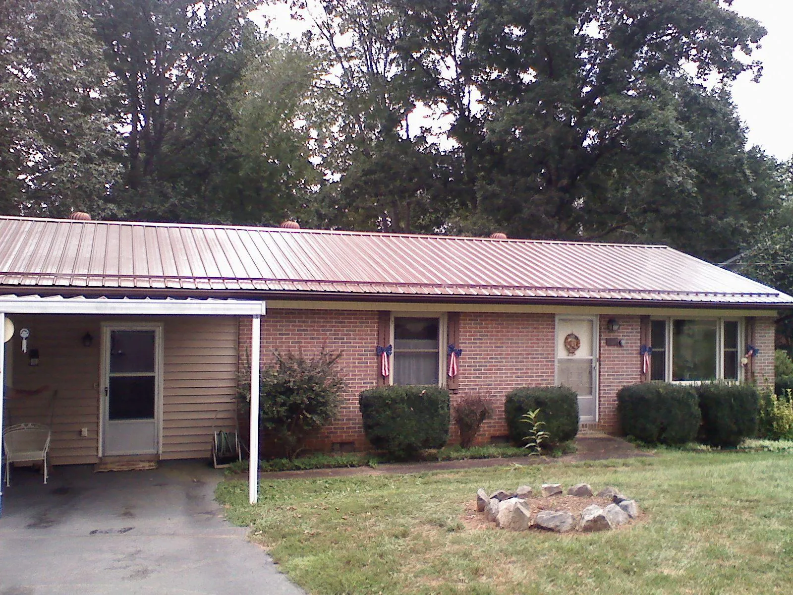 Bronze metal roof and carport on a brick ranch home — Roof Repair work by our crew in Conway Springs